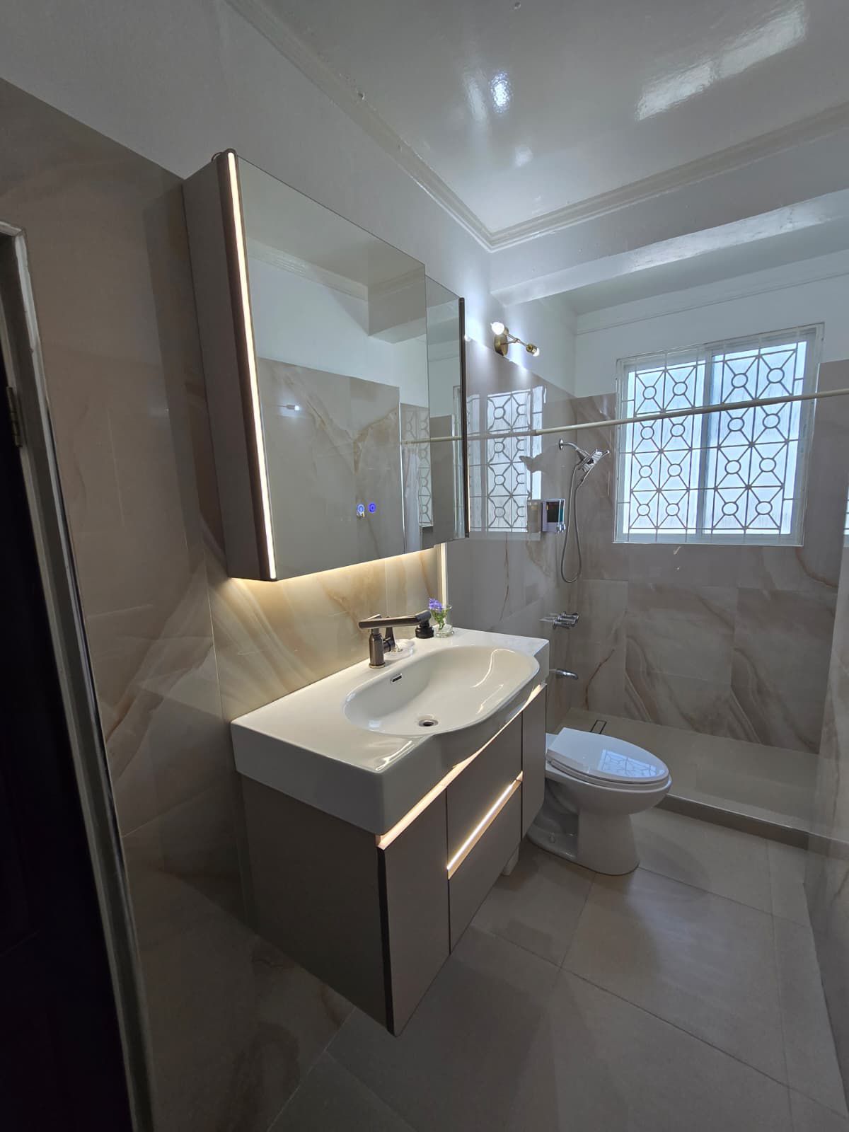 Modern luxury bathroom with elegant marble finishes and walk-in rain shower